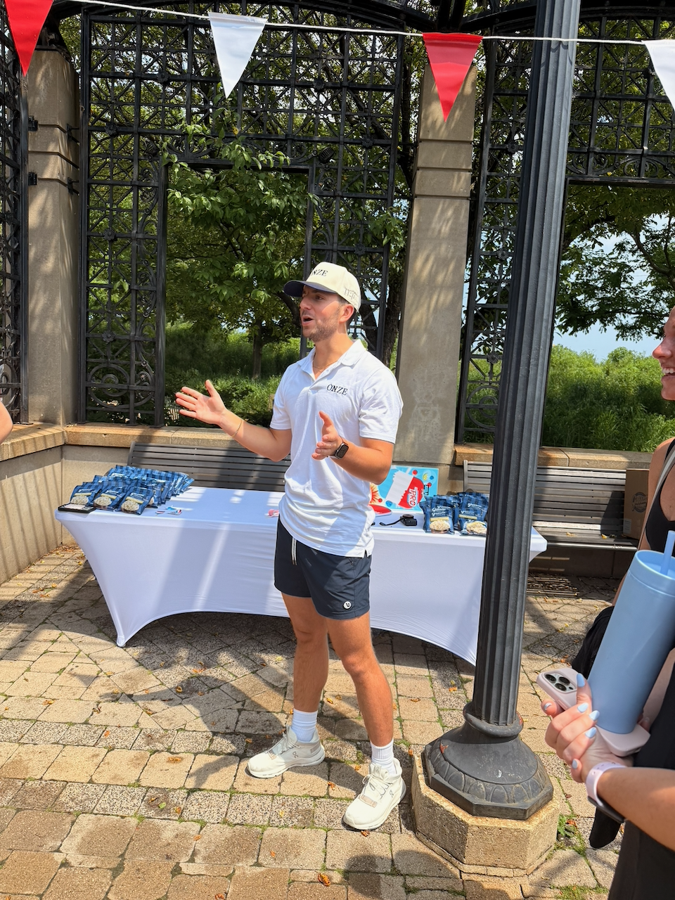 Josh Shikoff addressing the crowd at the sponsor table with Garrett's Popcorn samples